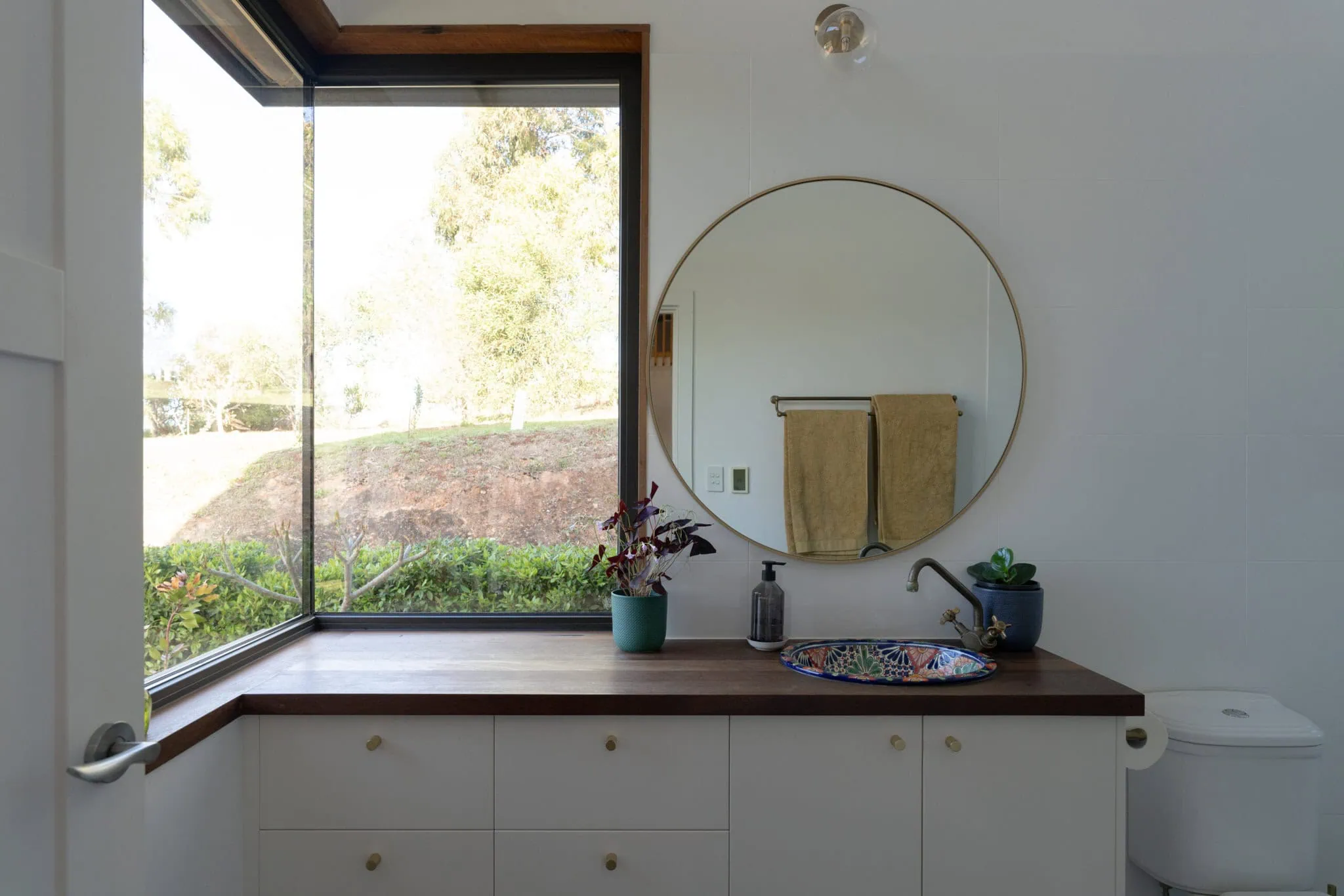 Bright bathroom featuring a large window, minimalistic design, and elegant accents.