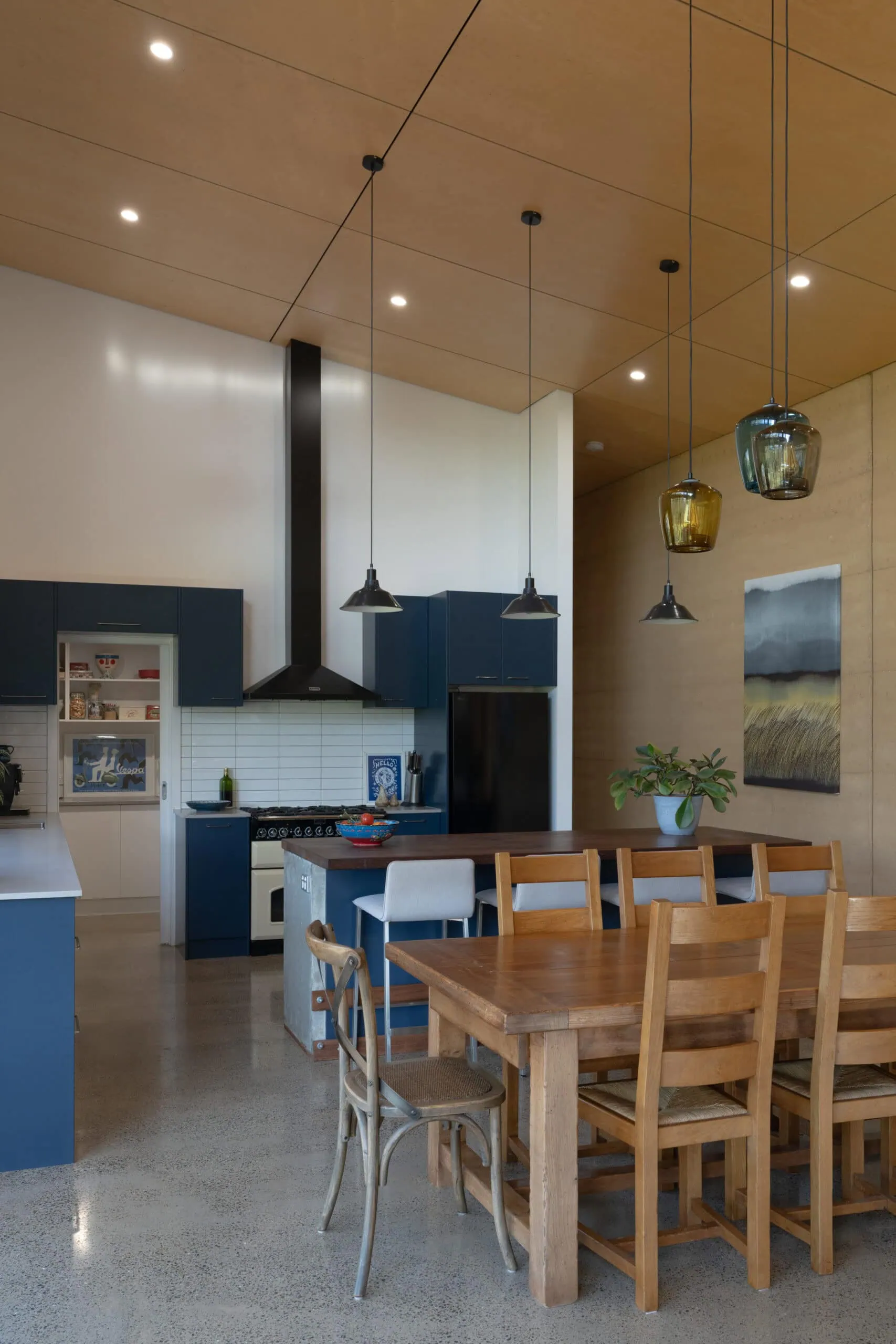 Stylish kitchen with timber ceiling, pendant lights, and modern cabinetry, showcasing high-end building craftsmanship.