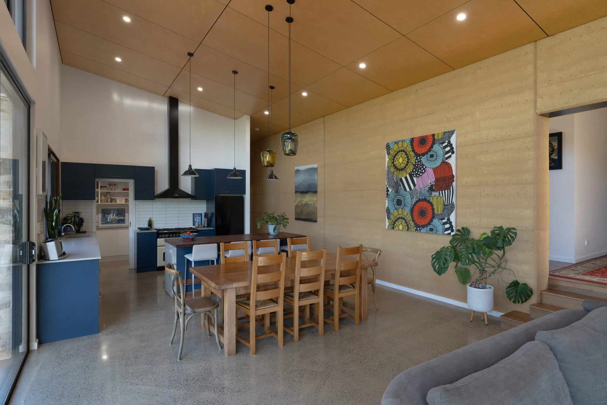 Stylish interior featuring a spacious dining table, artwork, and indoor plants.