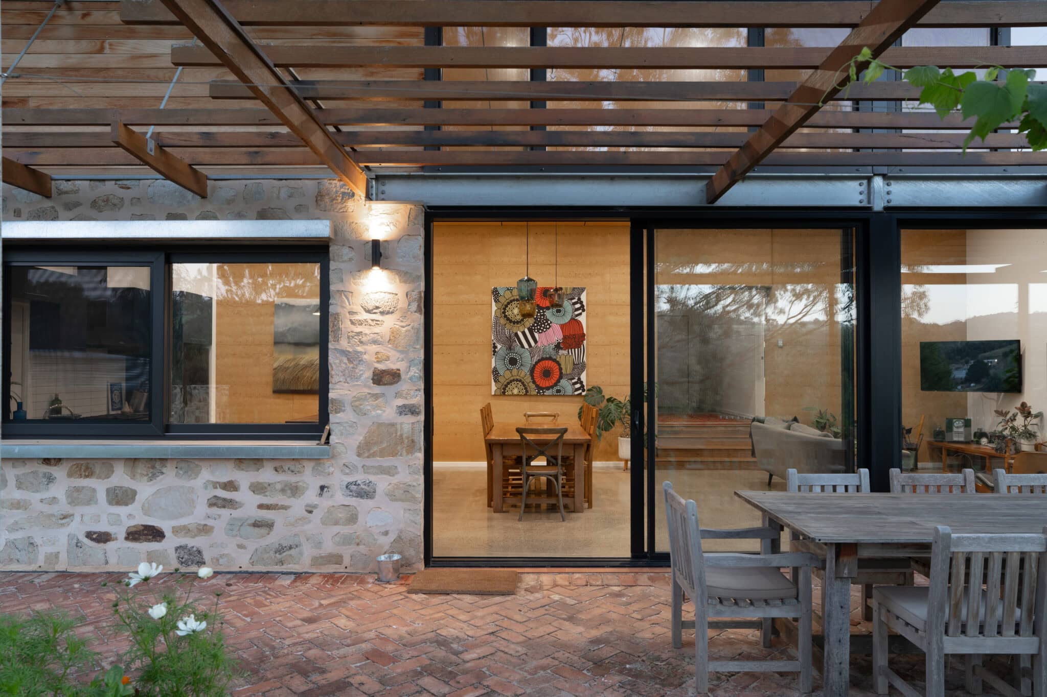 Aluminium sliding doors and stone wall accents for seamless indoor-outdoor connection in custom home renovations Australia.