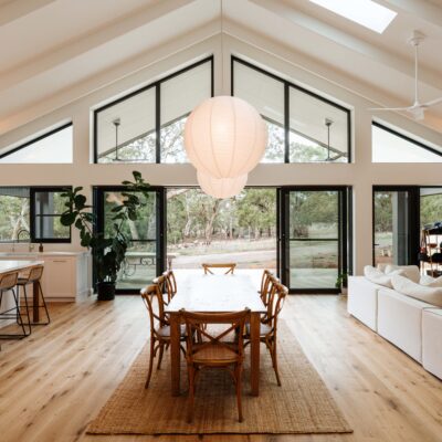 Spacious open-plan living and dining room with large windows, high ceilings, and modern furnishings.