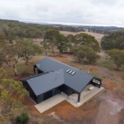 Modern rural home with metal roof and surrounding landscape.