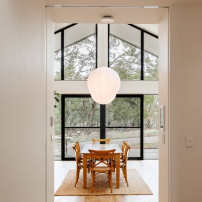 Bright dining area with large glass windows and vaulted ceiling, ideal for modern home interiors.
