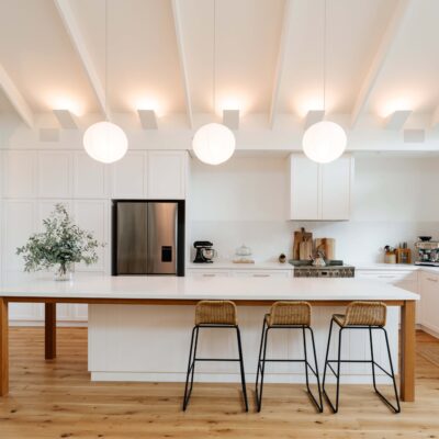 Contemporary kitchen featuring a spacious island, white cabinetry, and ample natural light for a bri.
