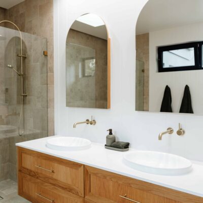 Modern bathroom with double vanity, large mirrors, and walk-in shower.