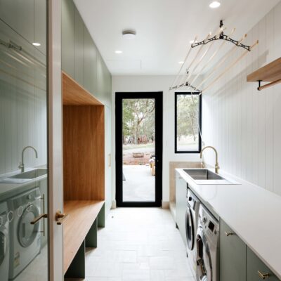 Bright laundry room featuring built-in washing machine and dryer with ample storage space.