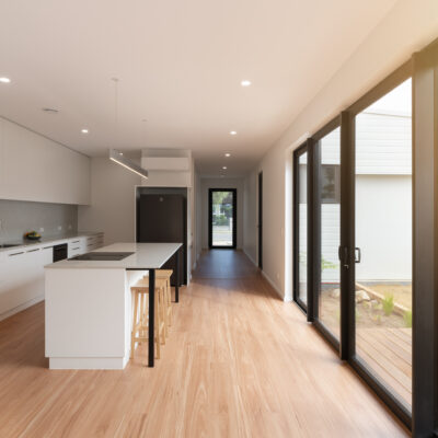 Contemporary kitchen with white cabinetry and large glass doors for Project West Beach.