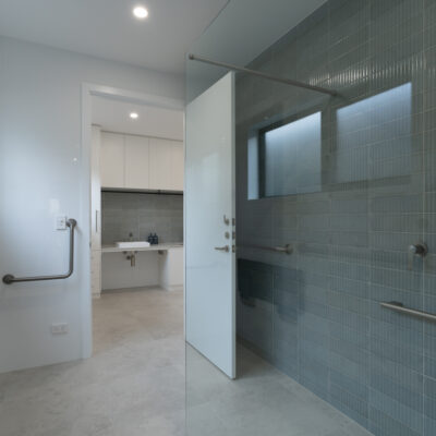 Accessible bathroom with walk-in shower and grab bars for safety.
