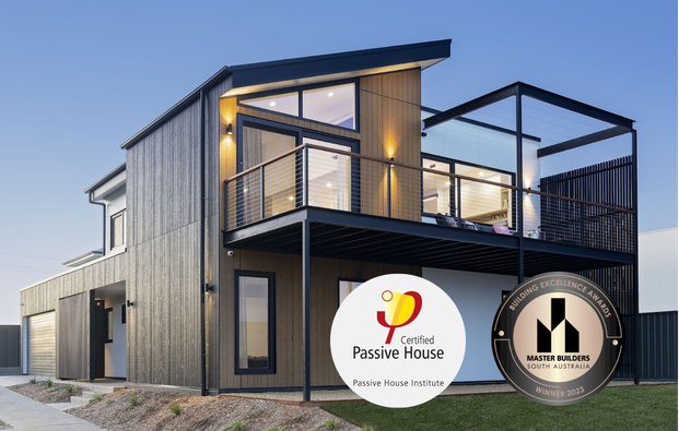Contemporary two-storey passive house with large balcony and modern design features.