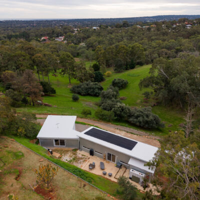 Contemporary house with solar panels in lush green landscape, Aberfoyle Park project.