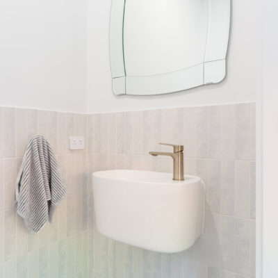 Contemporary bathroom with wall-mounted sink and stylish mirror.