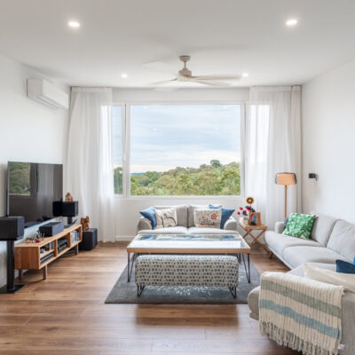 Spacious living room with large window, comfortable sofas, and modern decor.