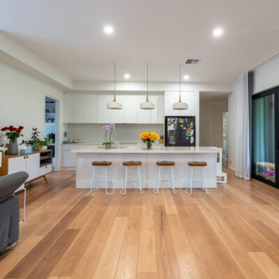 Contemporary open-plan kitchen and living space with wooden flooring.