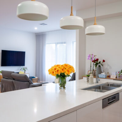 Contemporary kitchen with white countertops and pendant lighting.