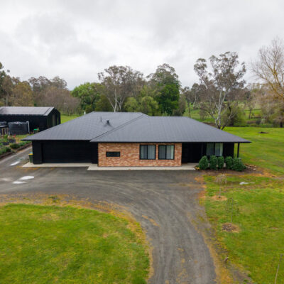 Contemporary single-story house with brick and black exterior in Woodside.